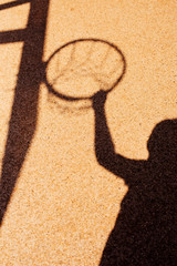 Shadow of male basketball player in slam dunk pose
