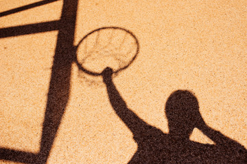 Shadow of male basketball player in slam dunk pose
