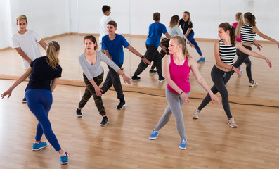 Fototapeta na wymiar sports teenage boys and girls learning in dance hall