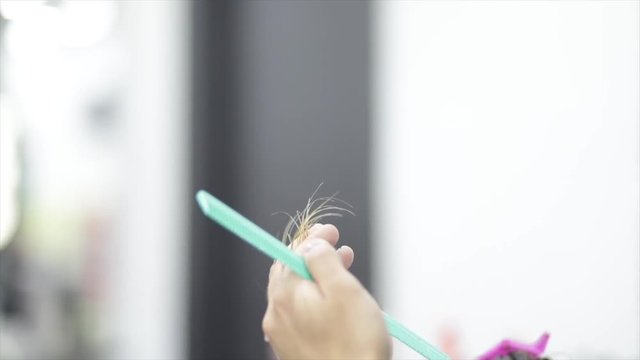 Slow motion close up, hairdresser snips hair