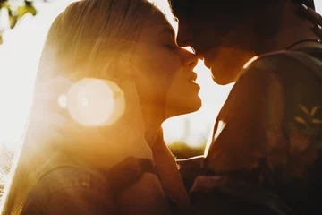 Poster Close up portrait of a beautiful young couple waiting to kiss in their traveling time against sunset light. © Strelciuc