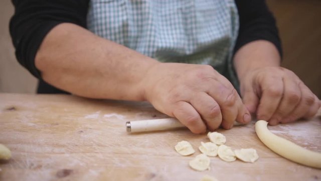 Chef cuts pasta dough, close up