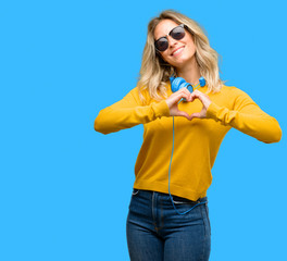 Young beautiful woman with headphones happy showing love with hands in heart shape expressing healthy and marriage symbol