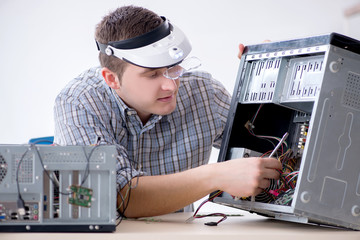 Young technician repairing computer in workshop