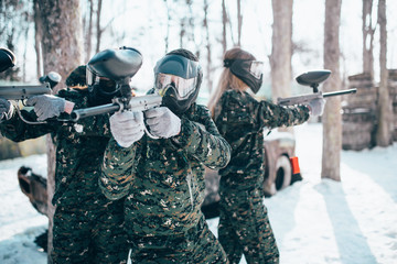 Paintball players in uniform and masks poses