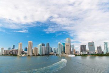 Fototapeta na wymiar Aerial view of Miami skyscrapers with blue cloudy sky, boat sail