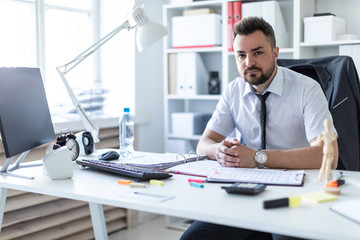 A man is sitting at a table in the office.