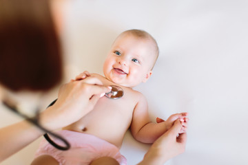 Baby at the doctor getting breath check up with stethoscope