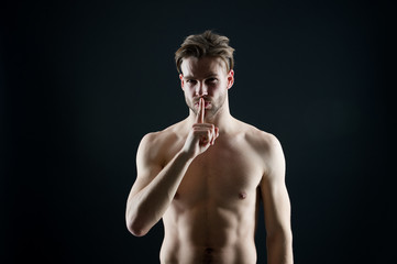Silence and secret concept. Sportsman show silence finger gesture. Bearded man with sexy chest and...