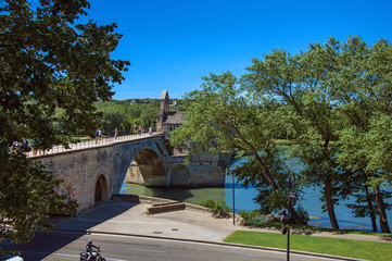Panoramic view of the Pont d'Avignon (bridge) and the Rhone River under the sunny blue sky, in the city of Avignon. In the Vaucluse department, Provence-Alpes-Côte d'Azur region, southeastern France