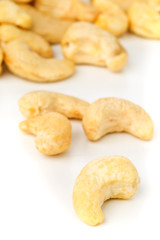 Close up of raw, organic, whole cashew nut kernels over white background
