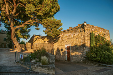 Fototapeta na wymiar View of traditional stone houses and walls on a street at sunset, in Chateauneuf-de-Gadagne. Located in the Vaucluse department, Provence-Alpes-Côte d'Azur region, southeastern France
