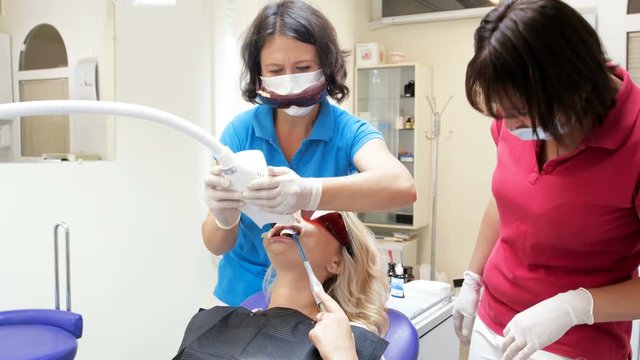 4k footage of dentist adjusting and turning on lamp for teeth whitening