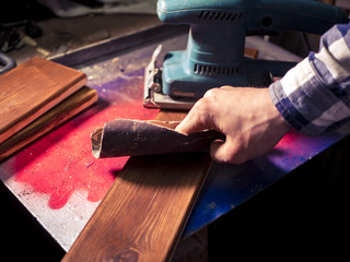 close up man working with wood grinding wooden bars in the workshop