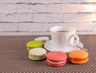 Cup of tea with colorful french macaron