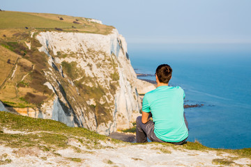 Man standing by the very edge of the cliff near Dover