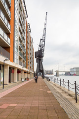 Huge black crane monument standing by the river bank at the docks in London near Excel