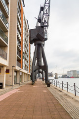 Huge black crane monument standing by the river bank at the docks in London near Excel