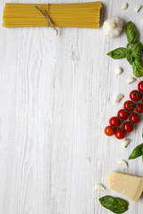 Set of ingredients for cooking pasta on a white wooden background. Top view. Flat lay. Copy space.