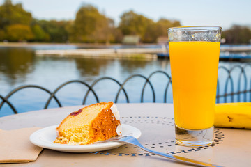 Early morning breakfast in the Hyde park in London. Fresh orange juice, a piece of cake, and some...
