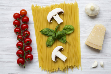 Different ingredients for cooking pasta on a white wooden background. Top view. Flat lay. From above.
