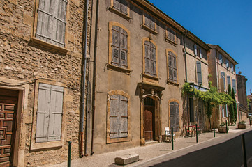 Fototapeta na wymiar View of typical stone houses and shops on a street of the historical village of Lourmarin. Located in the Vaucluse department, Provence-Alpes-Côte d'Azur region, southeastern France