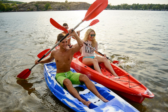 Friends Having Fun on Kayaks on Beautiful River or Lake at Sunset