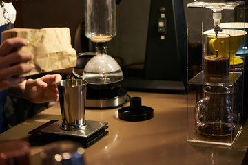 Barista weighs coffee on scales before preparing espresso. Professional barista equipment prepare for brewing drip coffee