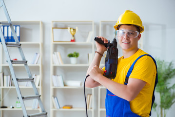 Young repairman with power drill