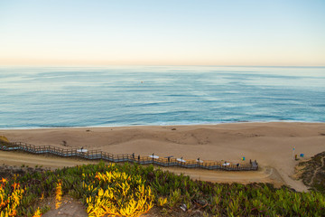 Beautiful ocean view from above on surfers going for the beach. Early morning ocean view in...