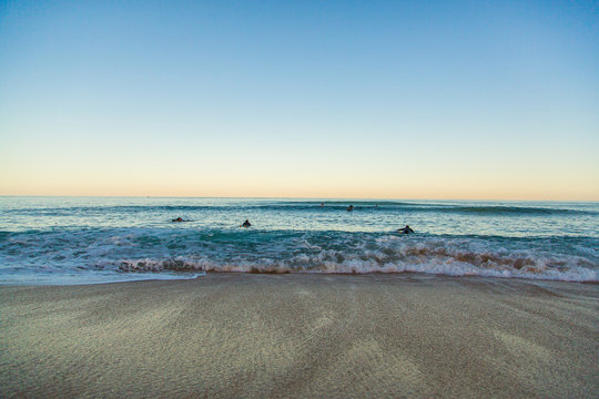 Beautiful ocean view from above on surfers going for the beach. Early morning ocean view in Portugal.