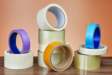 Several rolls of adhesive tape for different purposes on table.