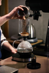 Barista weighs coffee on scales before preparing espresso. Professional barista equipment prepare for brewing drip coffee