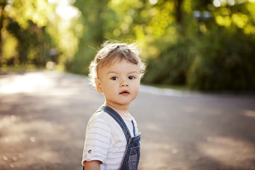 curly toddler on a walk in the park, large portrait.