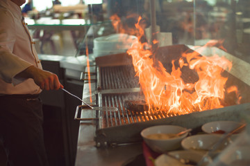 chef cooking steak with vegetables on a barbecue