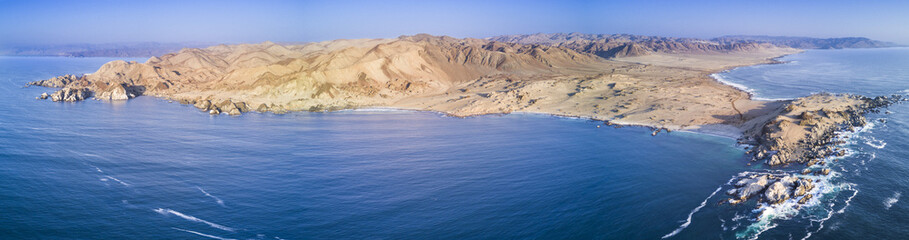 "Las Tortolas" beach at Atacama Desert with the last rays coming from the Sun in an aerial view from a drone