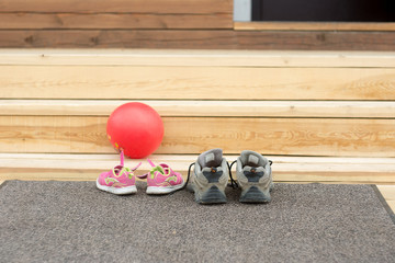 children's and adults sneakers are at the porch.