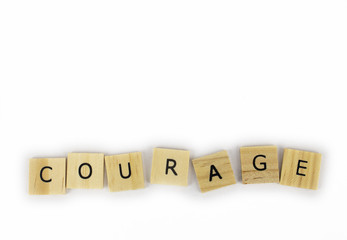 Wooden tiles spelling out the word courage on an isolated white background. Inspirational and motivational! Room for text! 
