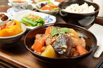A set menu  stew chicken with salad rice and soup . 