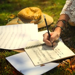 Woman writing a lyric in a notebook