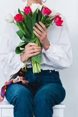 cropped view of woman with bouquet of tulip flowers, isolated on white