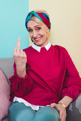 smiling senior woman showing middle finger