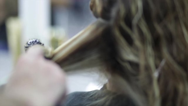 Slow motion, stylist brushes hair