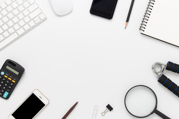White office desk with smartphone, computer and office supplies top view
