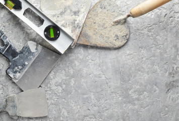 Building tools on a gray concrete background. Spatula, trowel, level, level, copy space, top view.