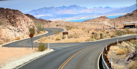 Smooth snaking paved roads heading to a lakeview overlook,  With Mead Lake and Nevada mountains in the background