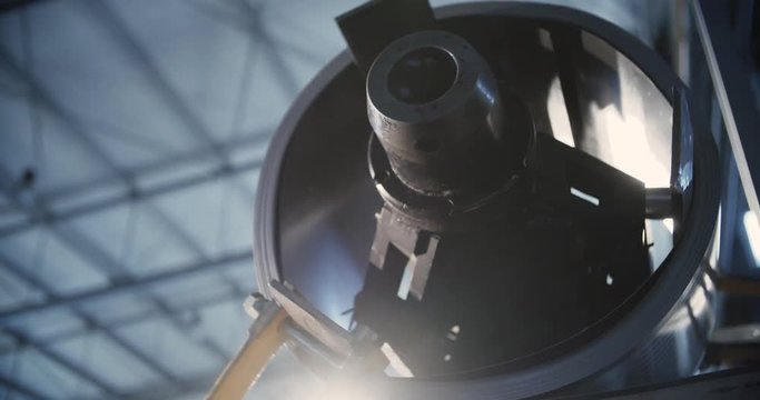 Hydraulic machine rotates and rolls sheet metal around a drum on the machine