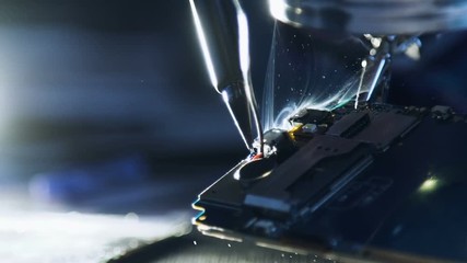 electronic renovation in repair shop. gadget recovery service technician soldering wires of broken mobile telephone