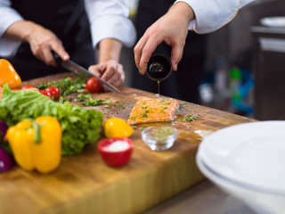 Chef hands preparing marinated Salmon fish