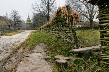 Wicker fence and straw thatched roof along the road
